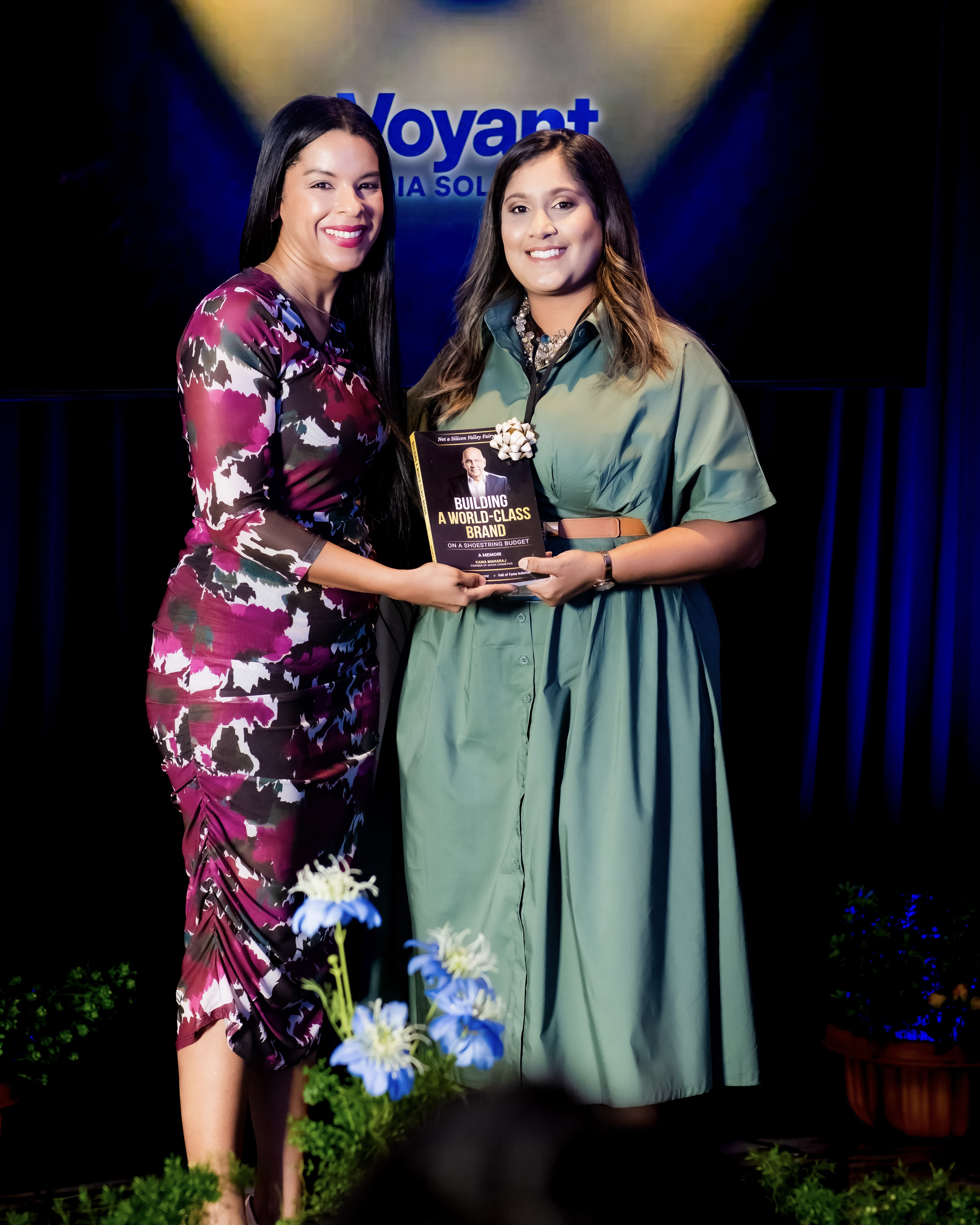 Samantha J. Best presents an autographed copy of Building a World-Class Brand on a Shoestring Budget to a guest