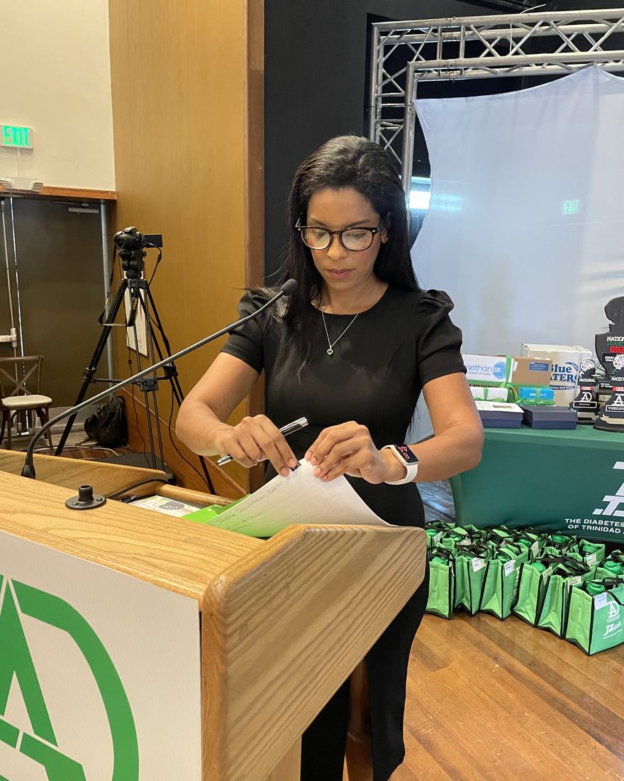 Samantha J. Best presenting at a lectern during a corporate event